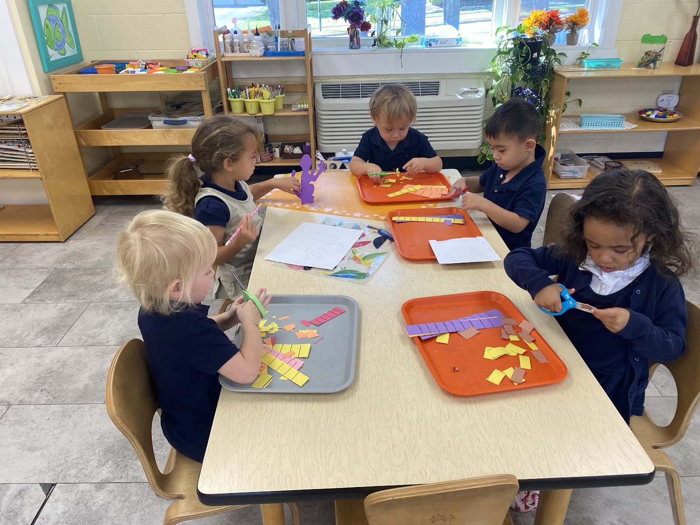 A toddler practicing cutting with scissors