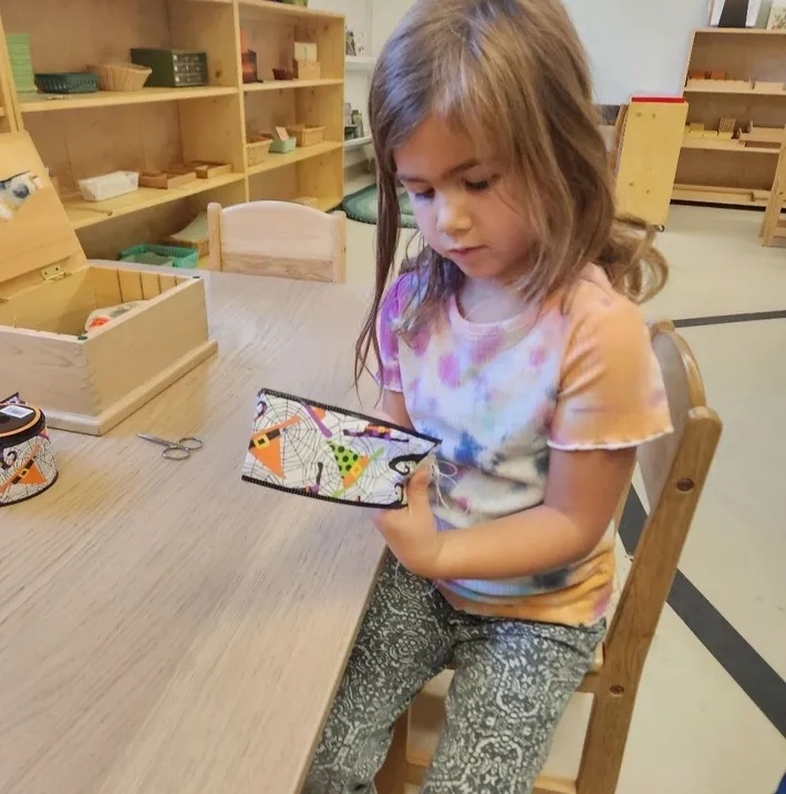 A child absorbed in independent work with a Montessori material in a bright classroom
